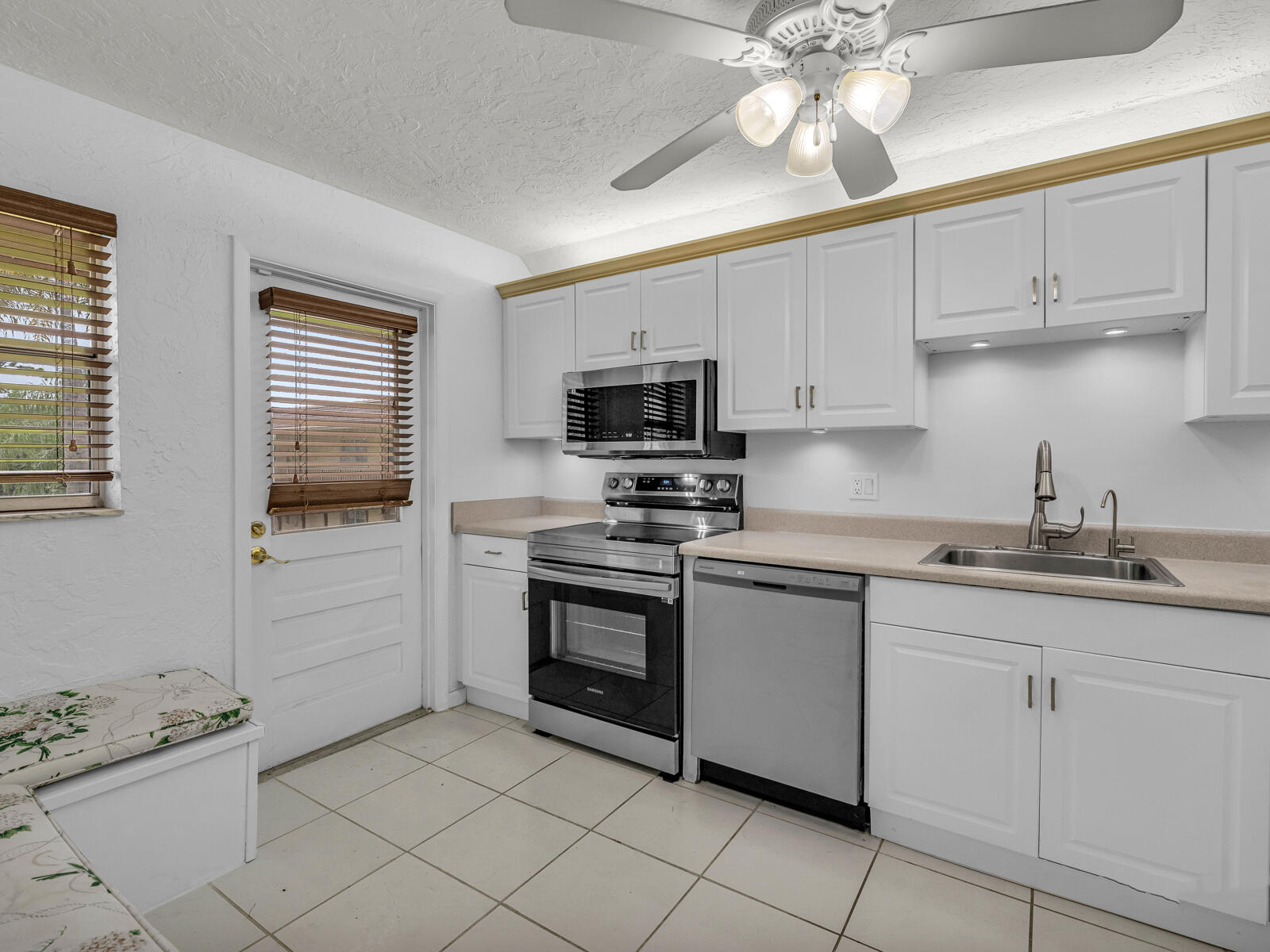 3001 Linton Boulevard, Unit 206C Delray Beach, FL 33445 - Photo 6 of 27 a kitchen with granite countertop cabinets stainless steel appliances and a window