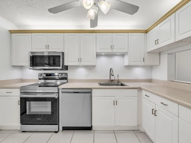 a kitchen with white cabinets and stainless steel appliances