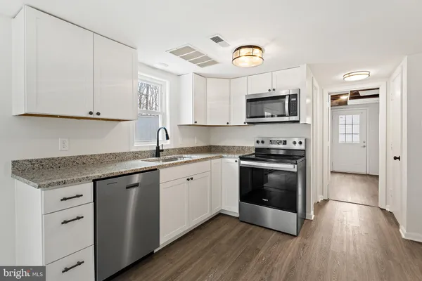 a kitchen with stainless steel appliances granite countertop a refrigerator and a stove top oven