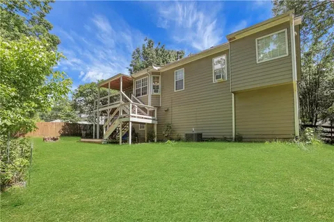 a white house with a small yard and big trees