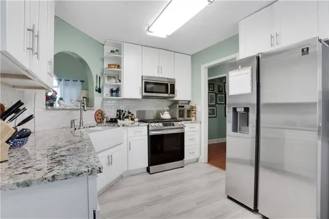 a kitchen with stainless steel appliances granite countertop a refrigerator stove and sink