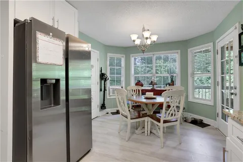 a view of a dining room with furniture a livingroom and chandelier