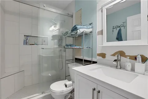 a bathroom with a sink a toilet and shower