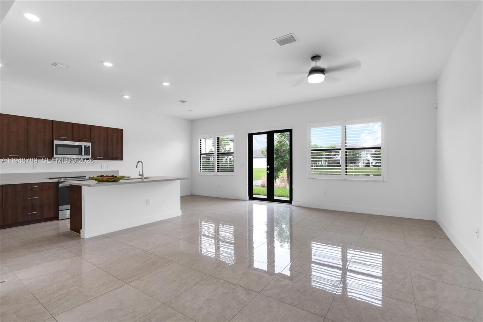 4538 Southwest 173rd Avenue Miramar, FL 33029 - Photo 11 of 48 a large white kitchen with kitchen island a sink stainless steel appliances and cabinets