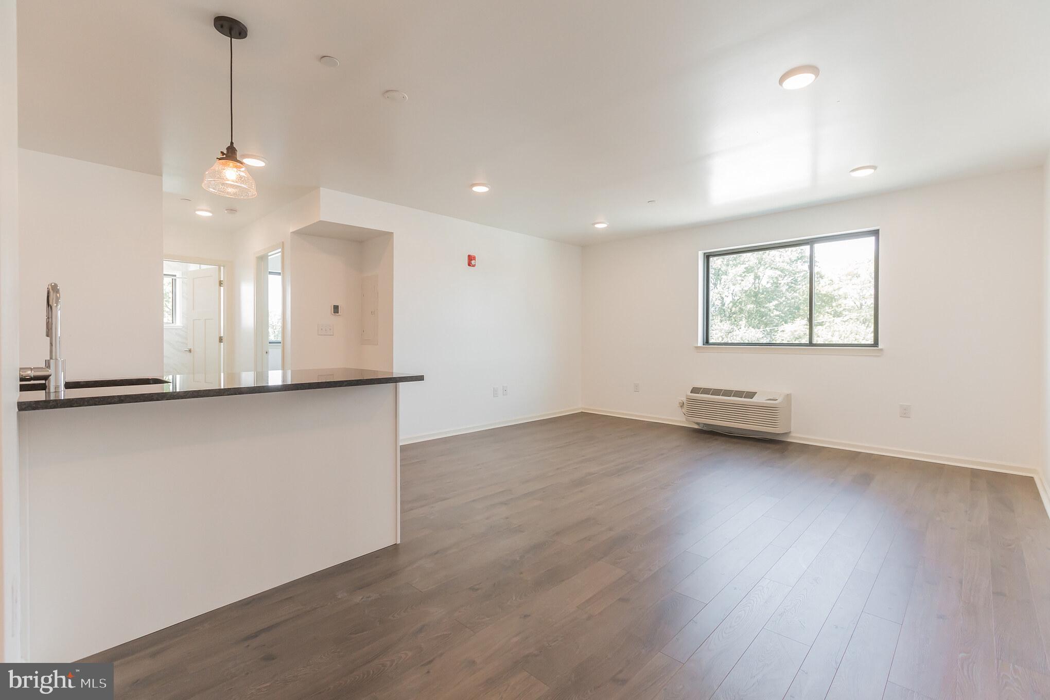 6778 Ridge Avenue, Unit 201 Philadelphia, PA 19128 - Photo 3 of 15 a view of an empty room with a window and wooden floor