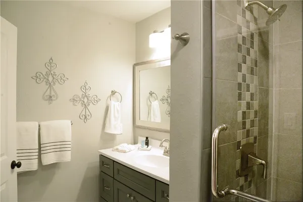 a bathroom with a sink mirror and shower