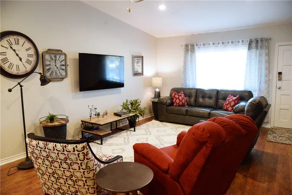 a living room with furniture a flat screen tv and a window