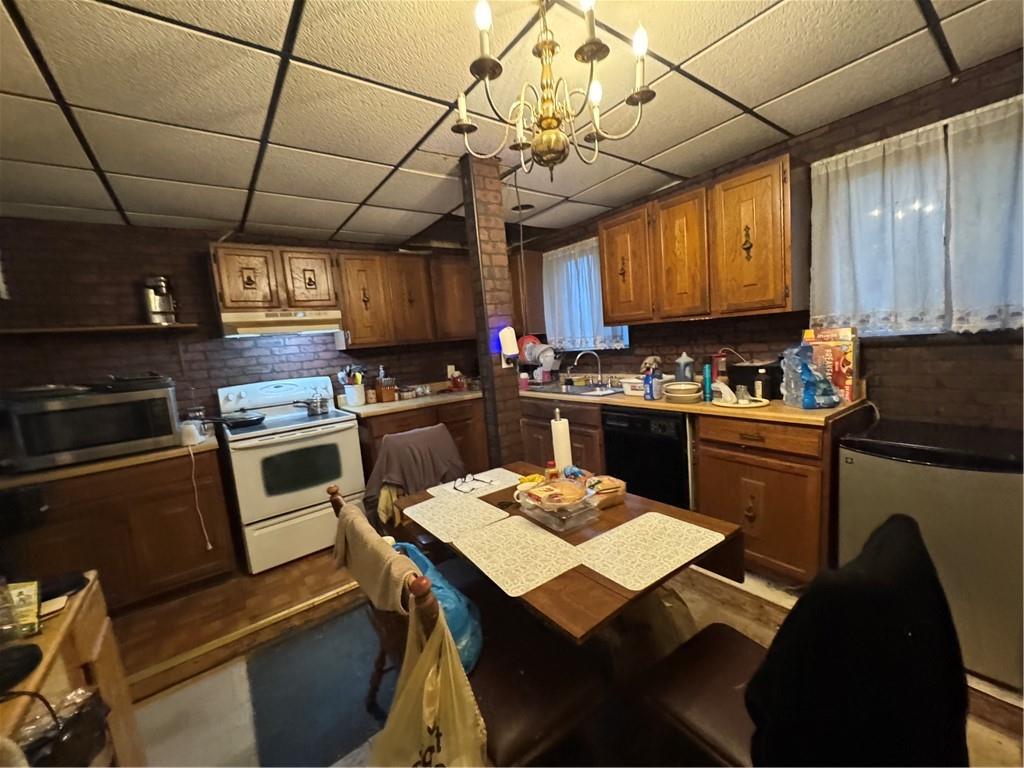 233 Alries Street Pittsburgh, PA 15210 - Photo 3 of 16 a kitchen with a table chairs microwave and cabinets