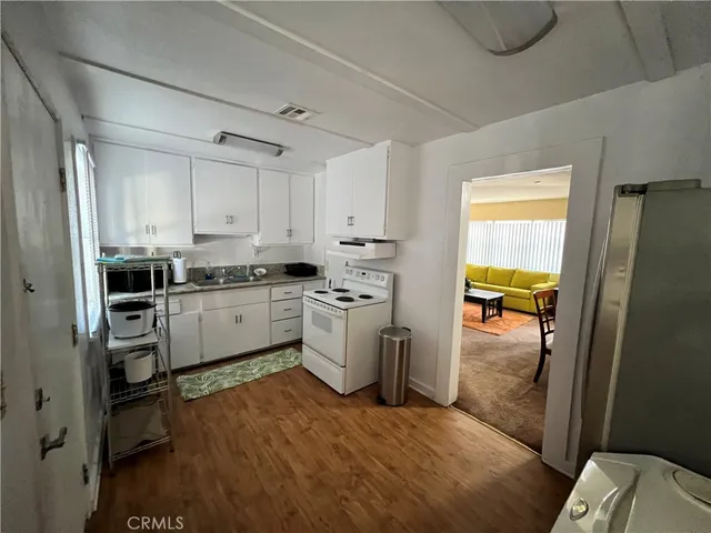 a kitchen with white cabinets and white appliances
