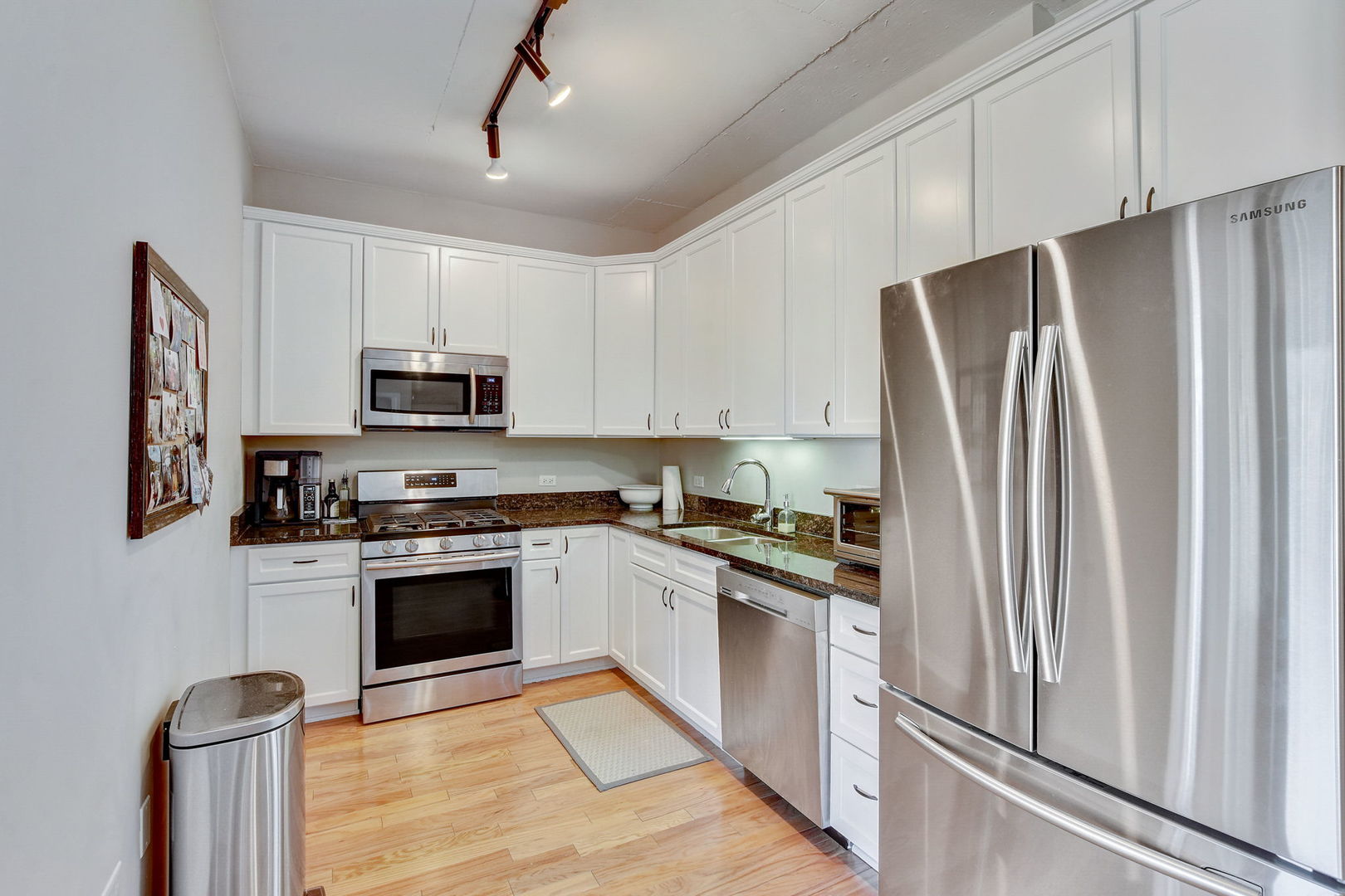 909 West Washington Boulevard, Unit 704 Chicago, IL 60607 - Photo 12 of 36 a kitchen with stainless steel appliances granite countertop a refrigerator stove and microwave