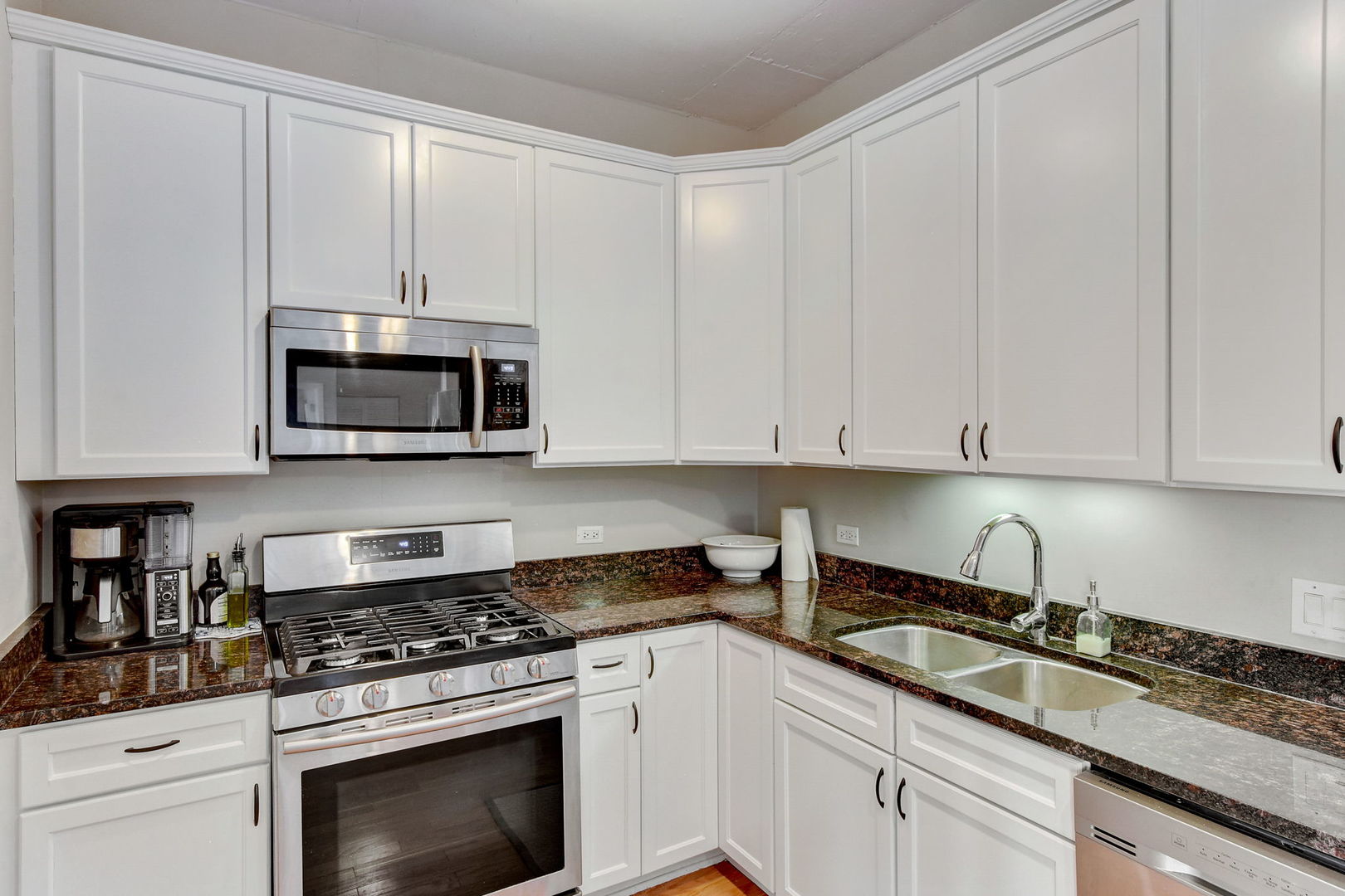 909 West Washington Boulevard, Unit 704 Chicago, IL 60607 - Photo 13 of 36 a kitchen with granite countertop white cabinets and stainless steel appliances