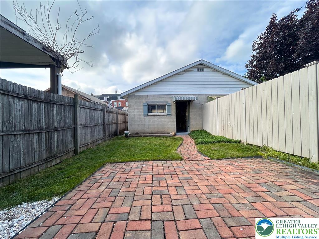 45 Evergreen Street Nazareth, PA 18064 - Photo 19 of 35 a view of a house with a small yard and a large tree with wooden fence