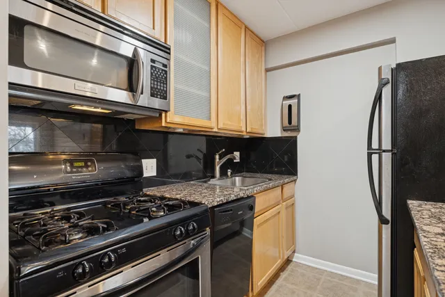 a kitchen with stainless steel appliances granite countertop a refrigerator and a stove top oven