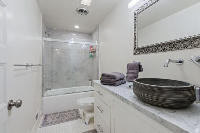 1900 North 100 East Provo, UT 84604 - Photo 34 of 49 Bathroom featuring a vessel sink atop a stone countertop, a wall-mounted faucet, and a decorative framed mirror