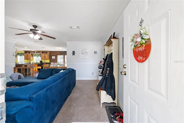 a living room with furniture a flat screen tv and a window