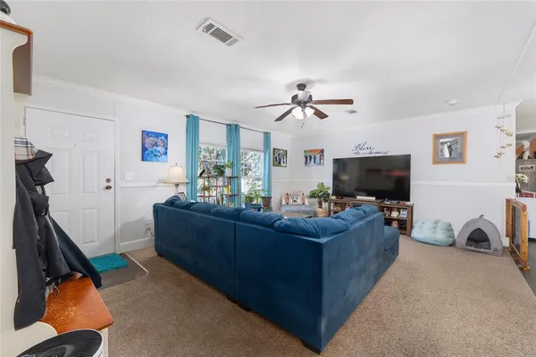 a living room with furniture a floor to ceiling window and a flat screen tv
