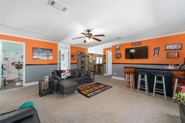 a bed sitting in a bedroom next to a window and a flat screen tv