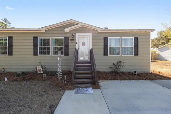a living room with furniture wooden floor and large windows