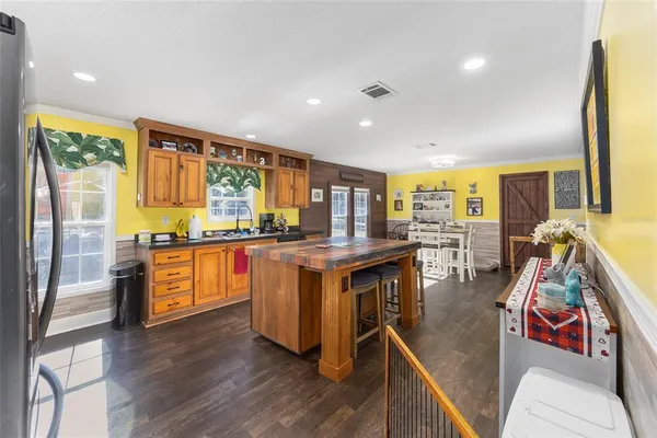 a kitchen with stainless steel appliances granite countertop a table chairs stove and wooden floor