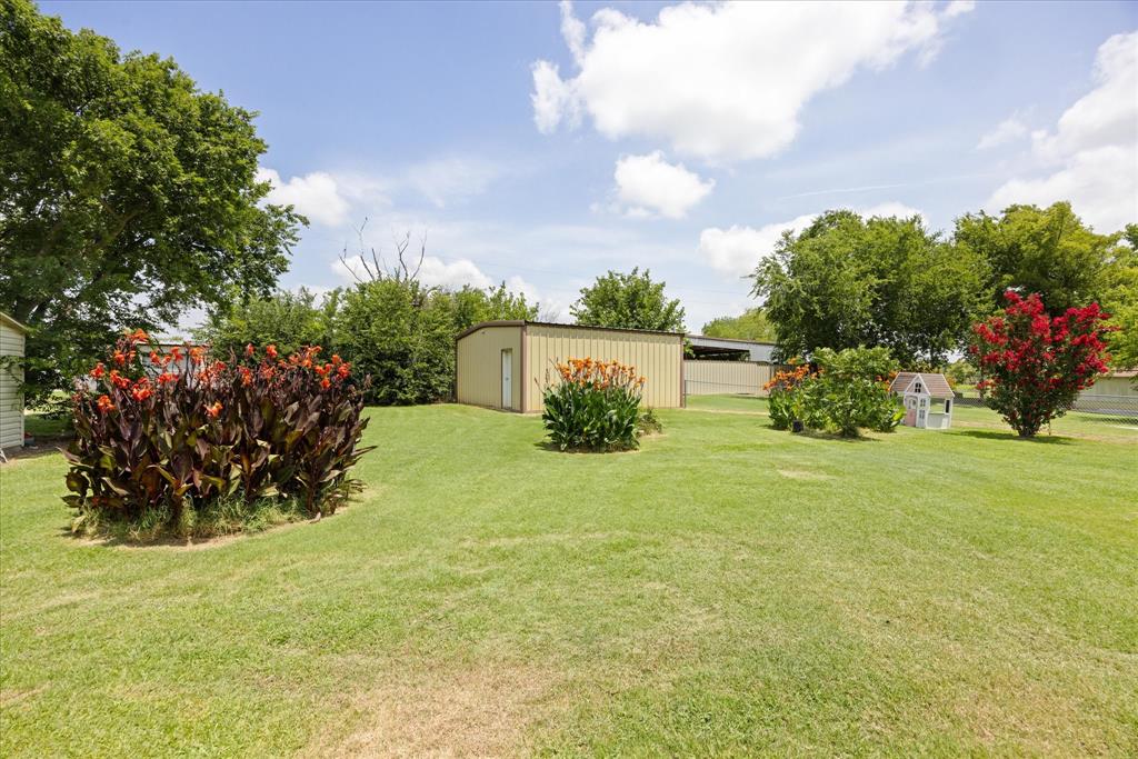 4210 Waples Road Granbury, TX 76049 - Photo 9 of 37 Expansive green lawn with mature trees and established garden beds