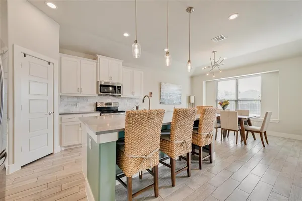 a large kitchen with cabinets table and chairs