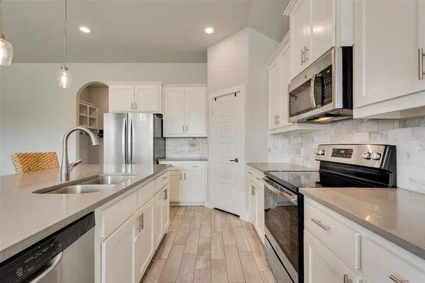 a kitchen with stainless steel appliances granite countertop a sink a stove and a refrigerator