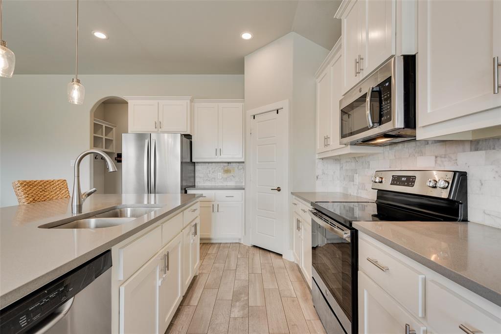 480 Collin Street Nevada, TX 75173 - Photo 12 of 27 a kitchen with stainless steel appliances granite countertop a sink a stove and a refrigerator