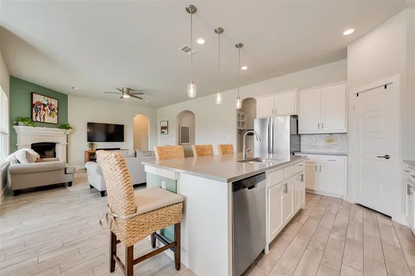 a kitchen with kitchen island a white cabinets and refrigerator