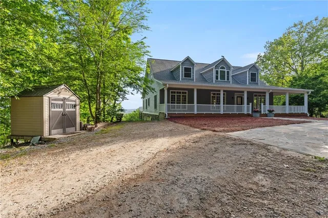 a view of small house with yard and sitting area