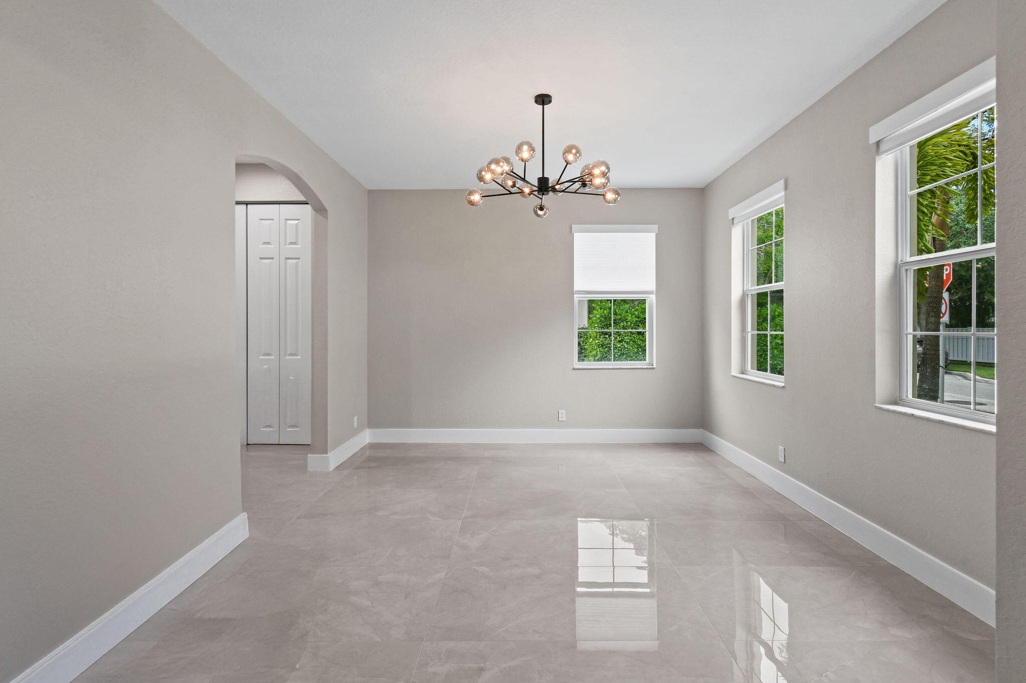 111 Tullamore Avenue Jupiter, FL 33458 - Photo 10 of 63 an empty room with windows and chandelier