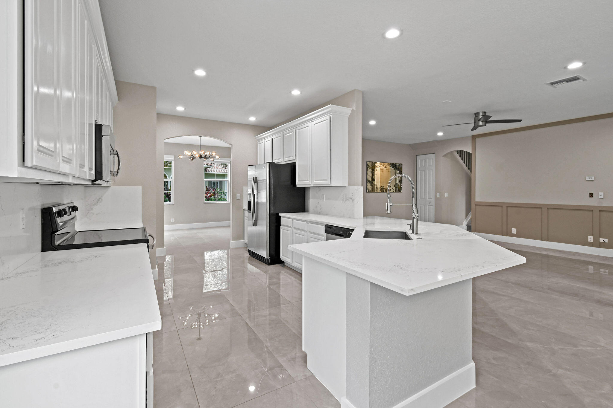 111 Tullamore Avenue Jupiter, FL 33458 - Photo 18 of 63 a large white kitchen with a stove a sink a refrigerator and white cabinets