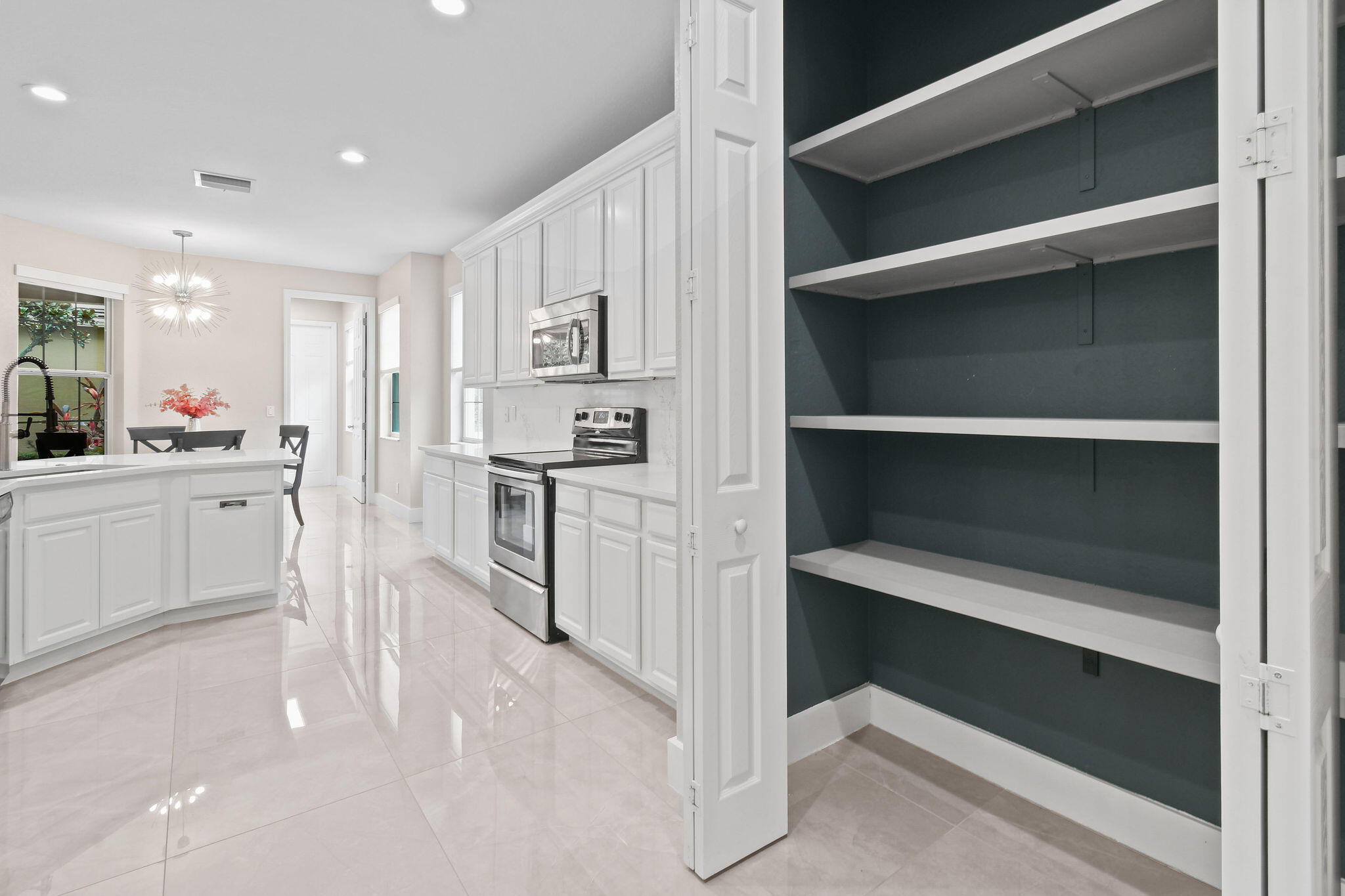 111 Tullamore Avenue Jupiter, FL 33458 - Photo 20 of 63 a open kitchen with white cabinets and stainless steel appliances