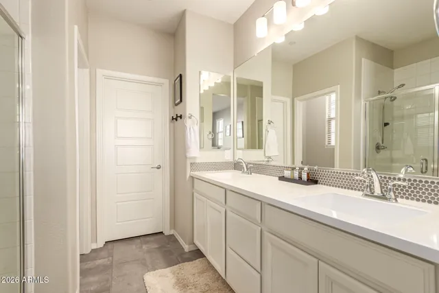 a bathroom with double sink and a mirror