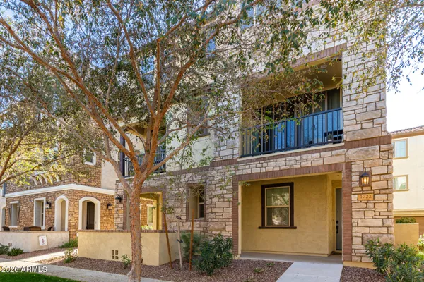 a front view of a house with a tree