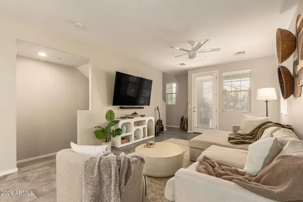 a living room with furniture a flat screen tv and a floor to ceiling window