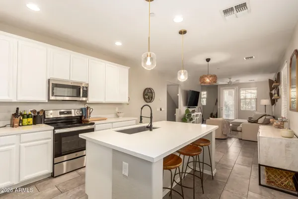 a kitchen with a stove a sink a dining table and chairs