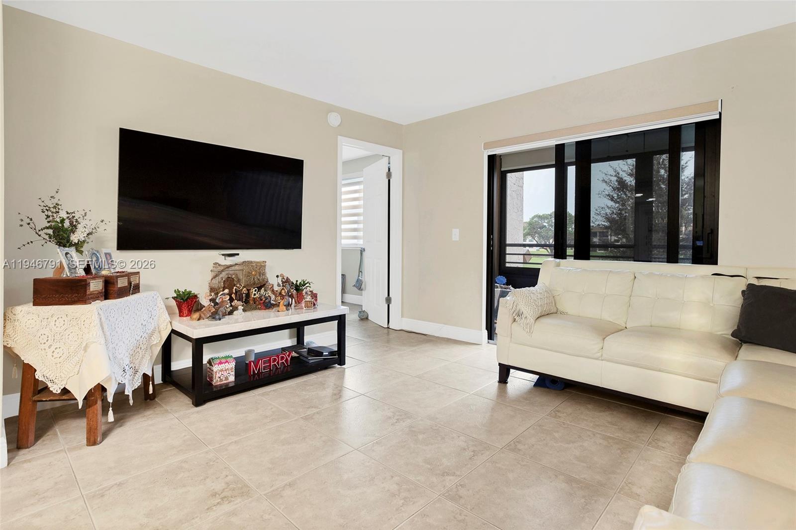 2941 North Nob Hill Road, Unit 208 Sunrise, FL 33322 - Photo 13 of 40 a living room with furniture and a flat screen tv