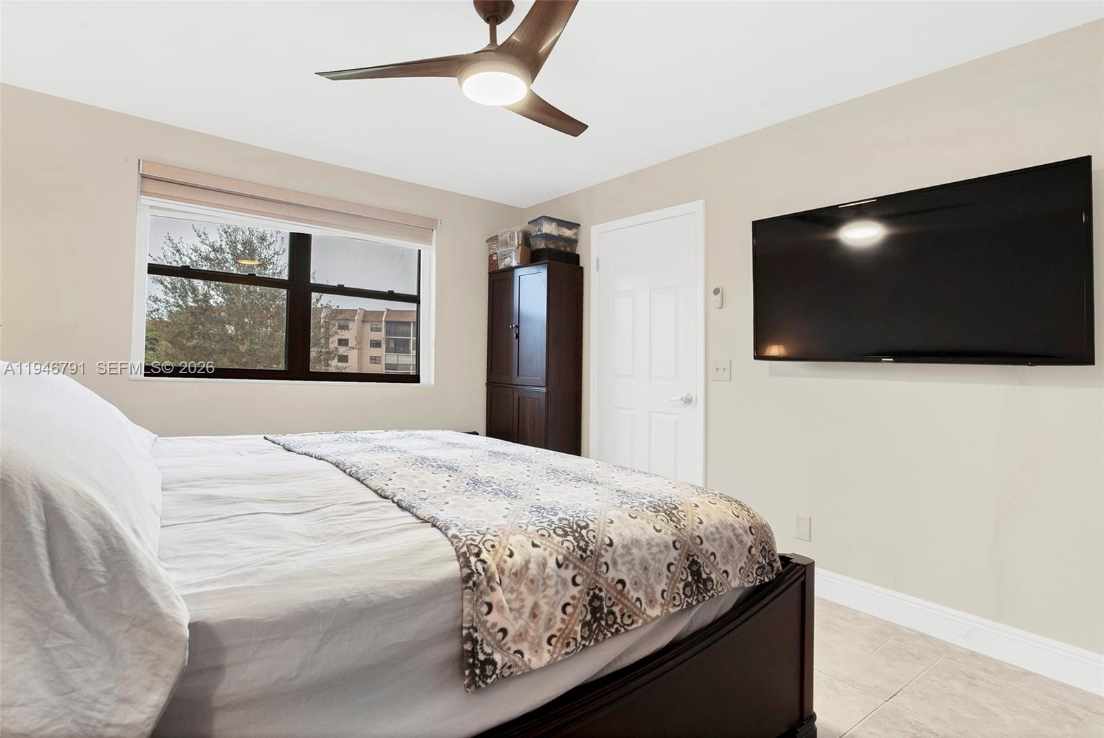 2941 North Nob Hill Road, Unit 208 Sunrise, FL 33322 - Photo 15 of 40 a bedroom with a bed and a flat screen tv