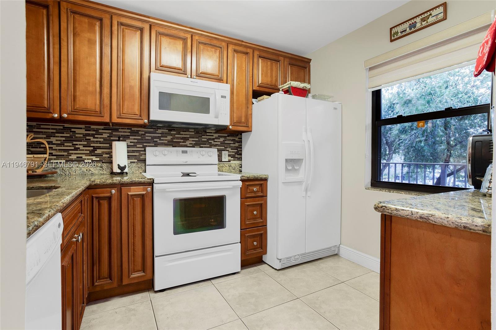 2941 North Nob Hill Road, Unit 208 Sunrise, FL 33322 - Photo 22 of 40 a kitchen with granite countertop cabinets stainless steel appliances and a window