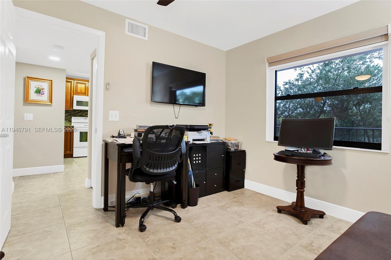 2941 North Nob Hill Road, Unit 208 Sunrise, FL 33322 - Photo 29 of 40 a view of a workspace with furniture and a flat screen tv