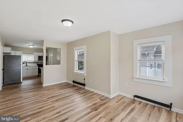 a view of empty room with wooden floor and window