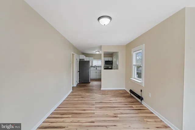 a view of a kitchen with wooden floor and electronic appliances