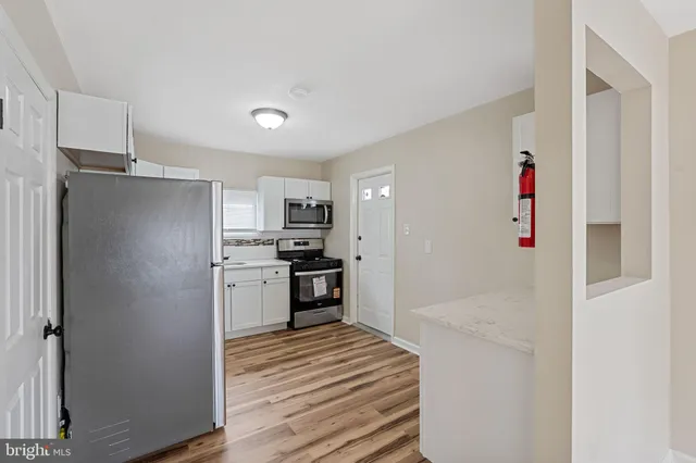 a kitchen with stainless steel appliances kitchen island granite countertop a refrigerator and a sink