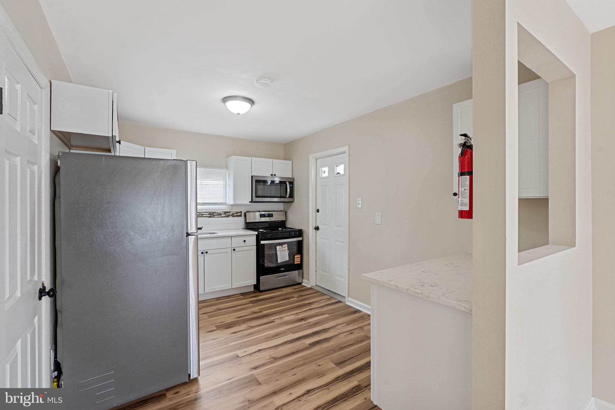 40 Wilson Road Clementon, NJ 08021 - Photo 9 of 31 a kitchen with stainless steel appliances kitchen island granite countertop a refrigerator and a sink