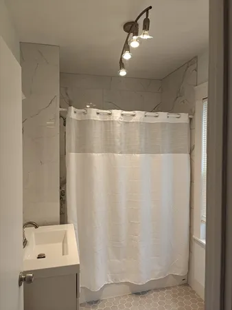 a bathroom with a shower and a sink