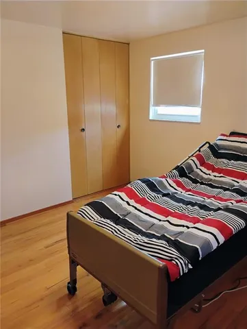 a bedroom with bed and wooden floor