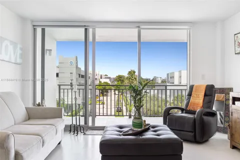 a living room with furniture and a floor to ceiling window
