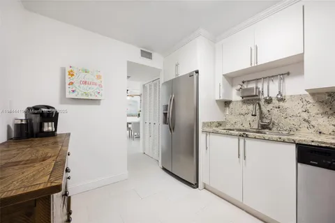 a kitchen with granite countertop a refrigerator and a sink