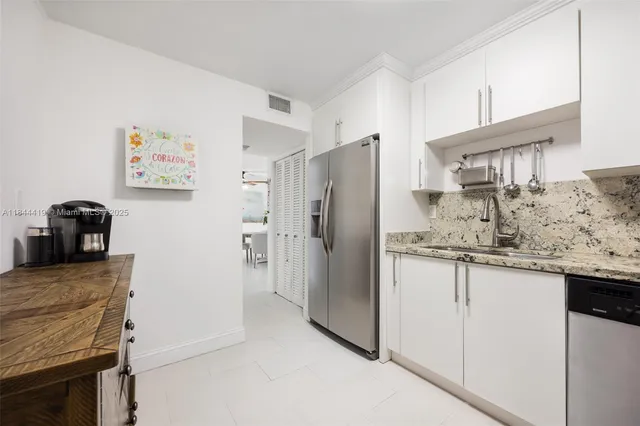a kitchen with granite countertop a refrigerator and a sink