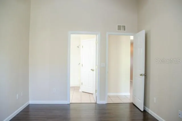 a view of empty room with wooden floor